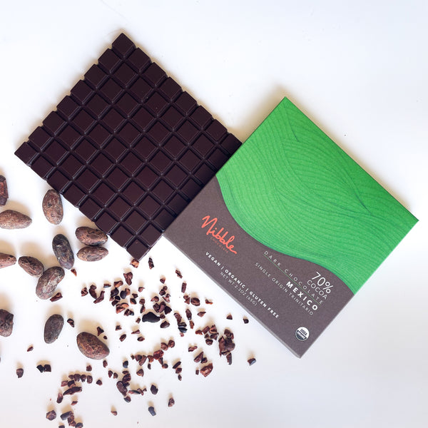 70% Mexico dark chocolate bar with green wrapper and scattered cocoa nibs