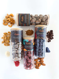 Flat-lay of assorted chocolate-covered nuts and beans glass jars