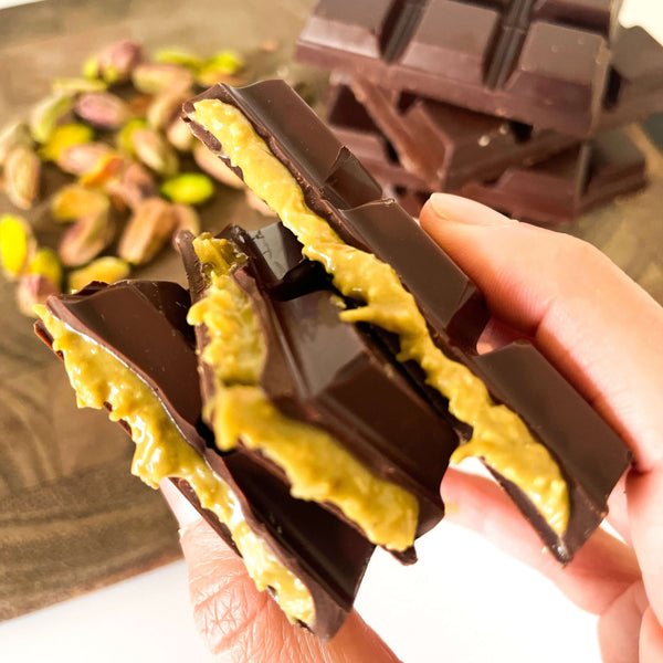 Spa Chocolate Bar with saffron and pistachio, held by hand – Dubai-inspired