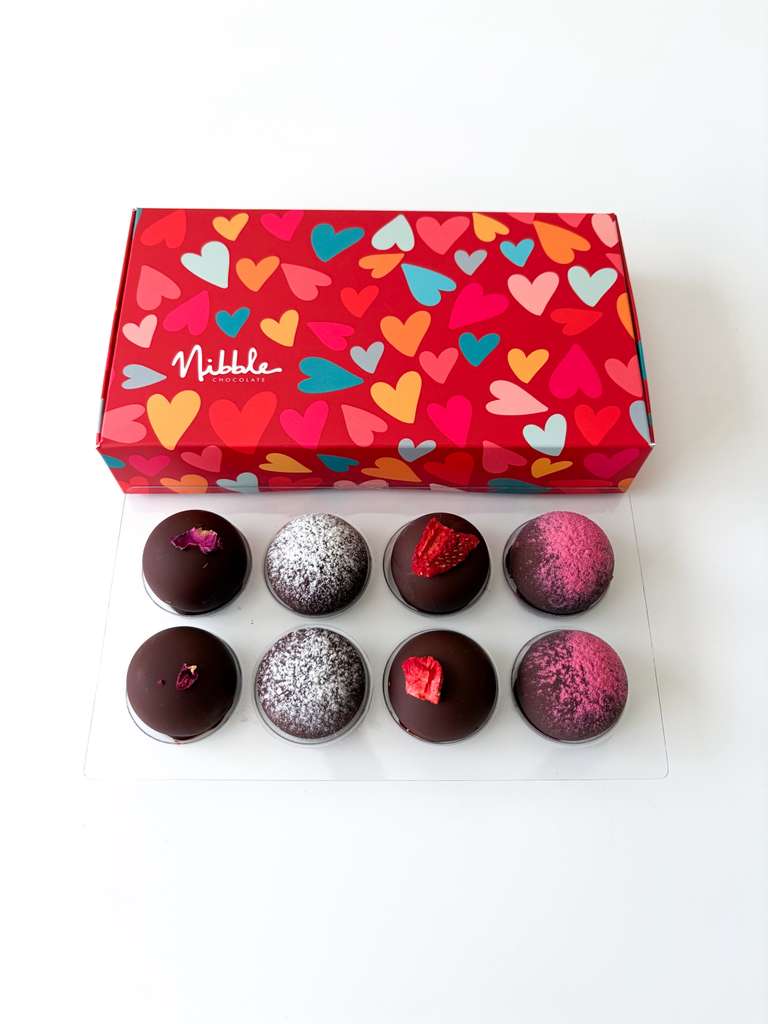 Box of chocolates with colorful heart pattern and Nibble branding on a white background
