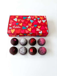 Box of chocolates with colorful heart pattern and Nibble branding on a white background